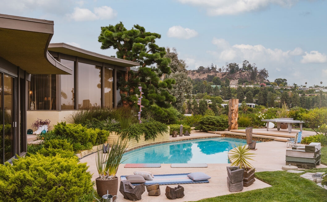 Prime Trousdale Estates Home poolside view of the city and walls of glass.