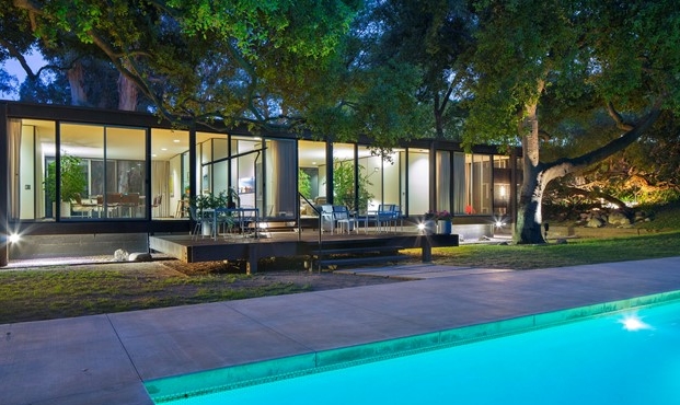 Incredible walls of glass overlook sparkling pool and rear yard. 