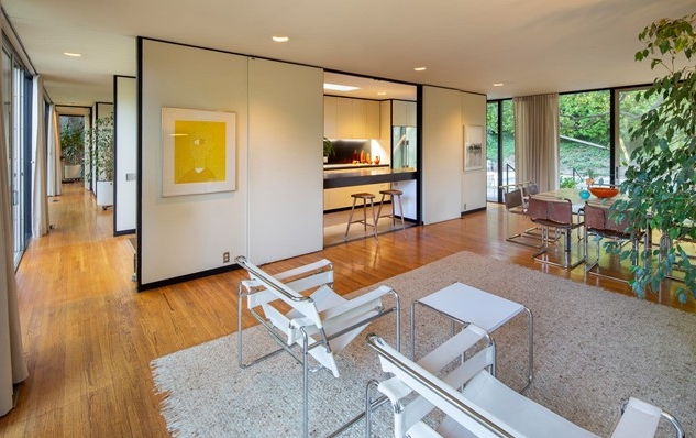 Open living area concept presents white walls, clean lines, and glass walls throughout.