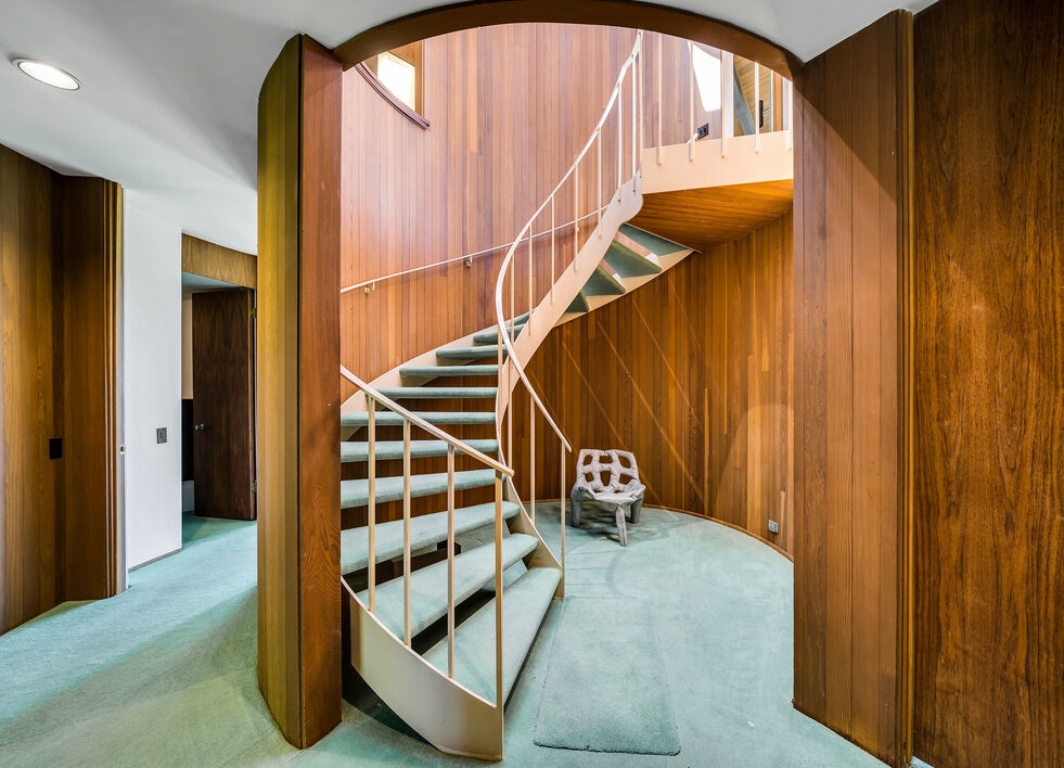 Fabulous wood enclosed spiral staircase leading you to the second floor.