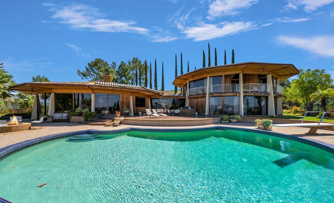 Magnificent home with walls of glass overlooking huge pool and entertaining patios with breathtaking views.