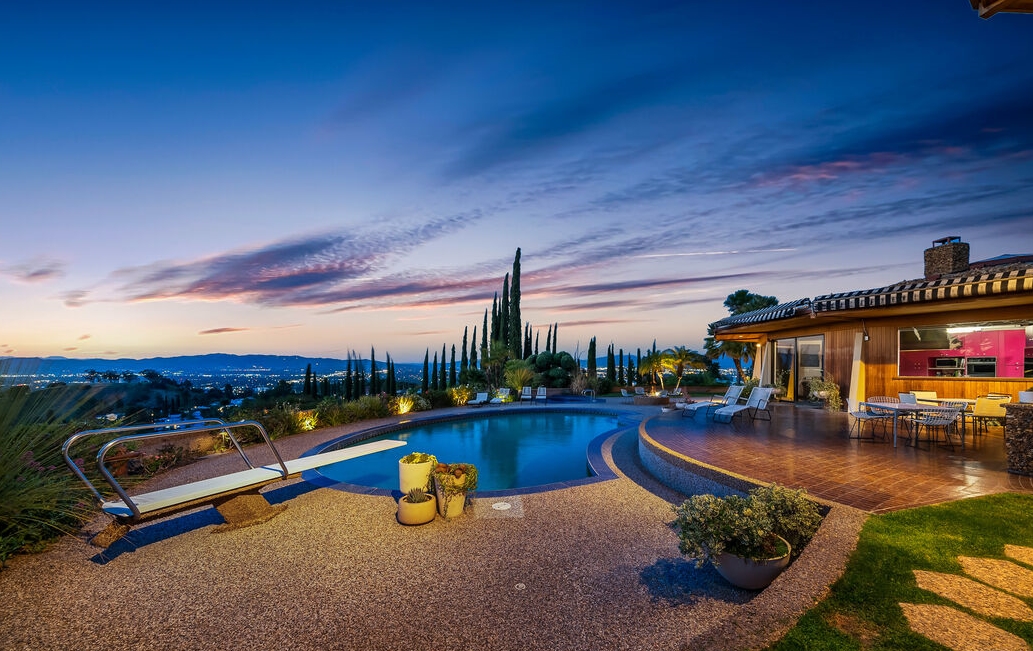 Magnificent home with walls of glass overlooking huge pool and entertaining patios with breathtaking views.