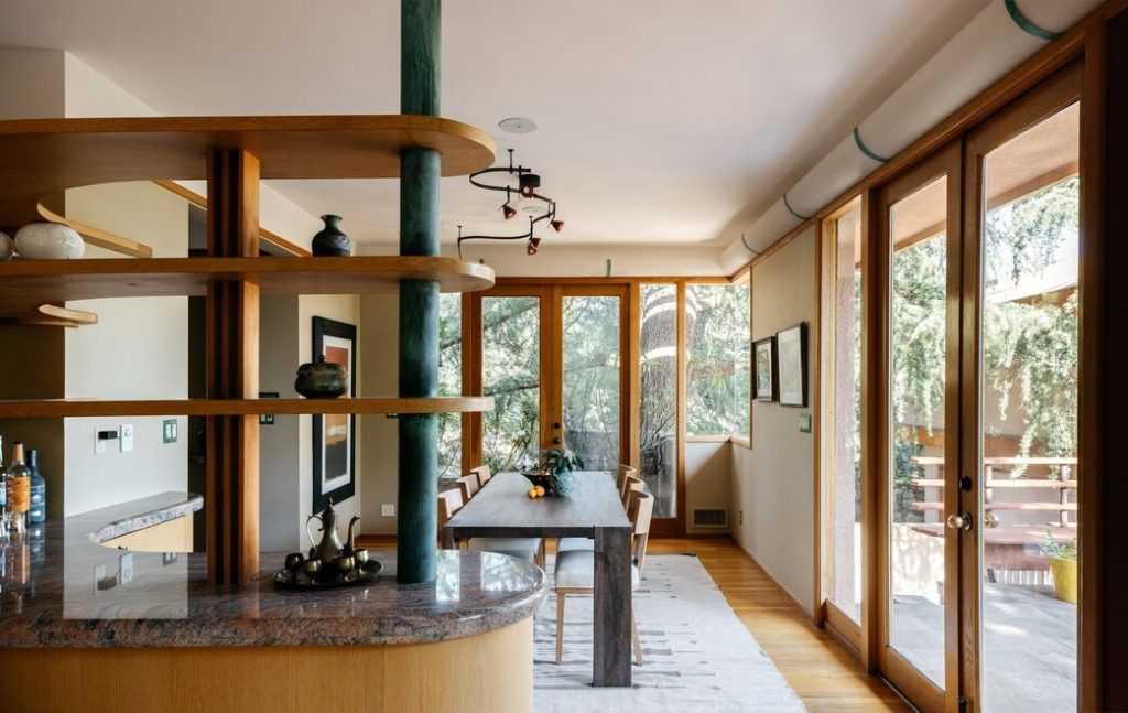With its rich original wooden cabinetry, the partially vaulted kitchen incorporates a two-story mitred window, skylights, and clerestory windows.