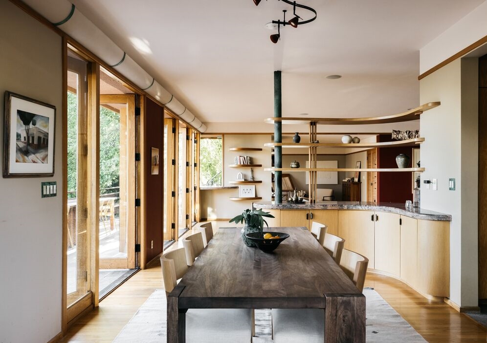 With its rich original wooden cabinetry, the partially vaulted kitchen incorporates a two-story mitred window, skylights, and clerestory windows. 