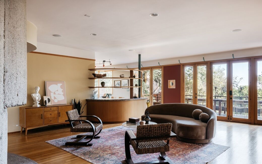  A large living area, open office/den and dining room are anchored by a two-story oval concrete fireplace, the rooms tied together by a 36-foot long lighting accent and the natural light from a continuous wall of glass doors. 