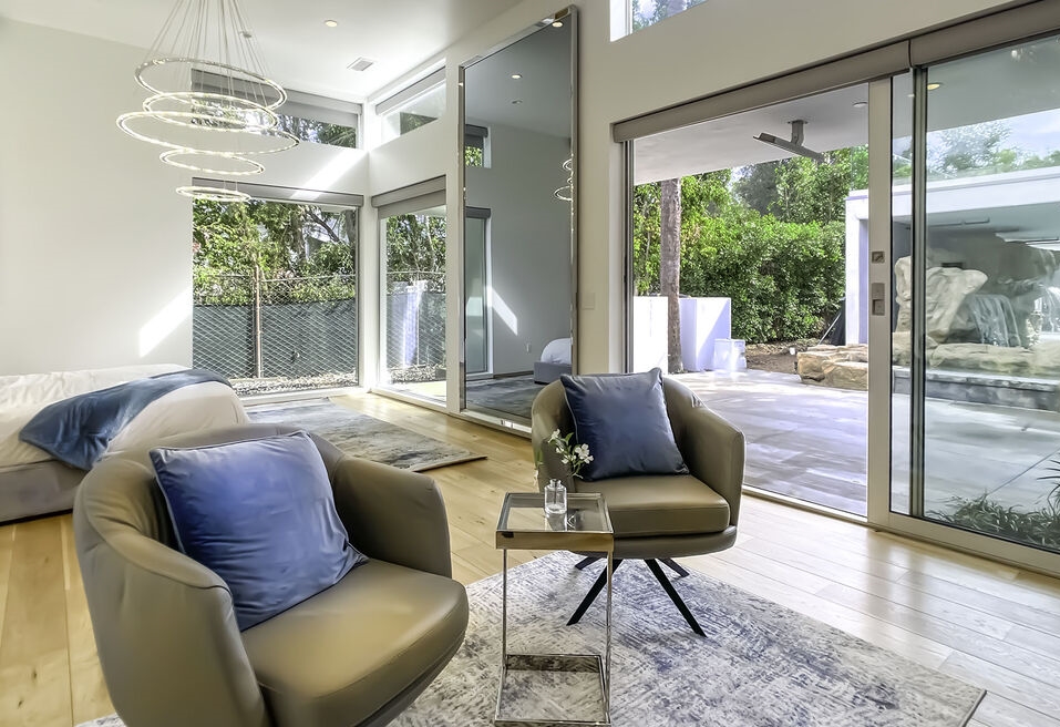 Guest sitting area romantically looks out to the beautiful backyard pool oasis.