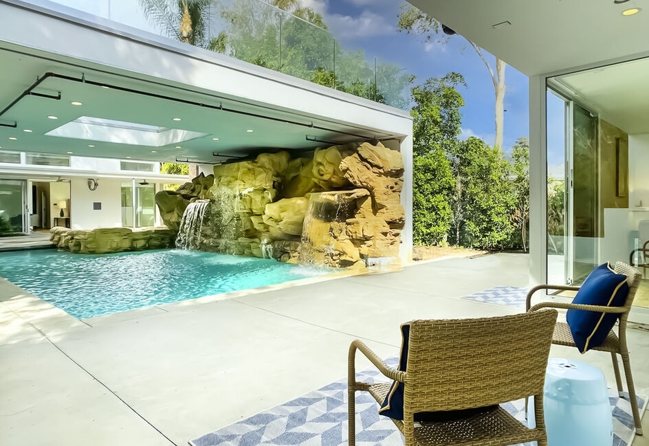 Amazing outdoor oasis with magnificent waterfall pool and overhead sun deck.