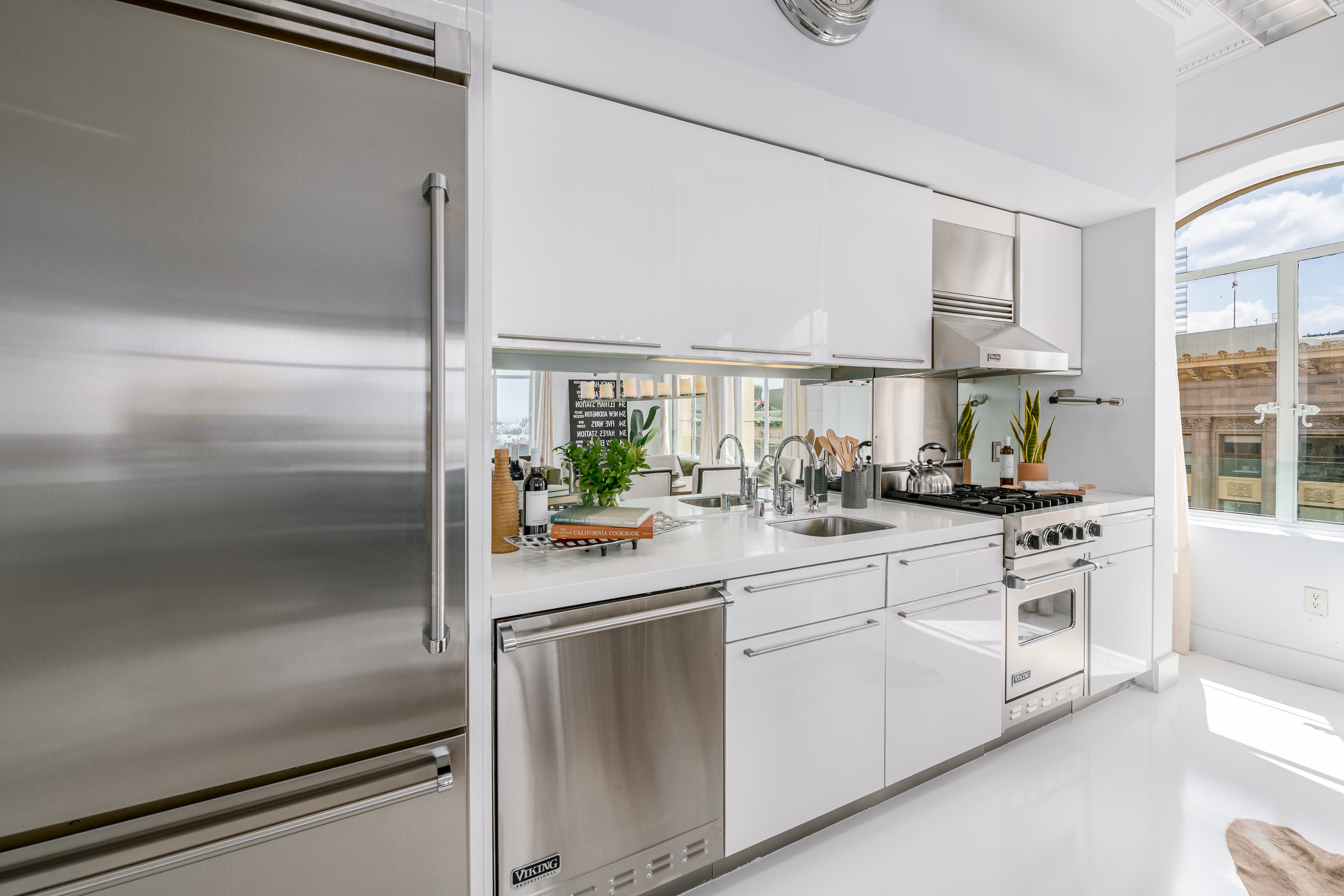 Stunning chef's kitchen with white walls and cabinetry, plus stainless steel appliances.