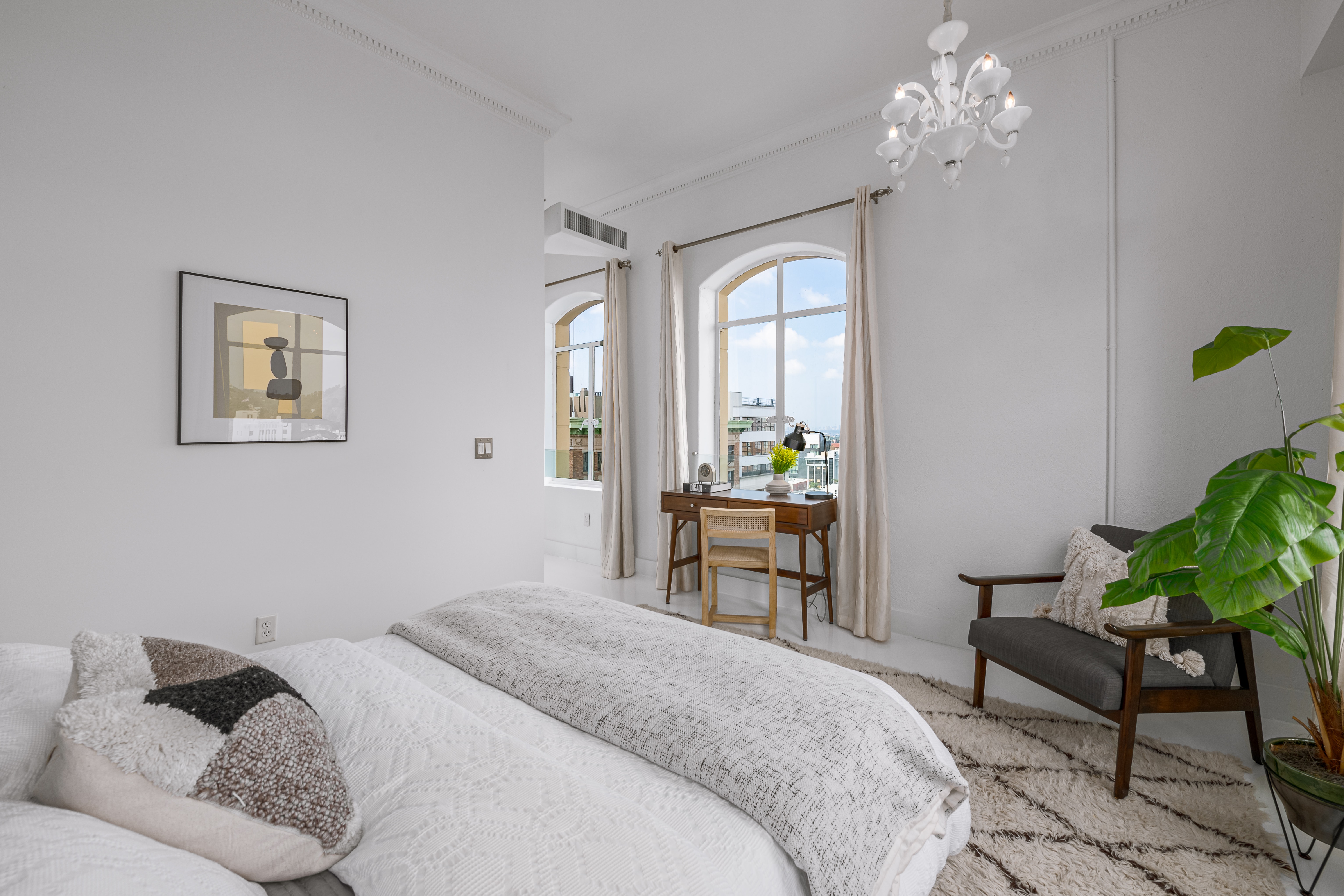 Dramatic white walls and arched windows in this spacious primary suite. Incredible views.