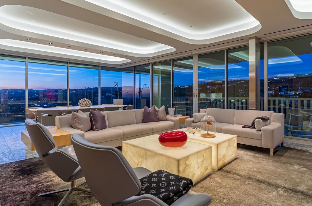 Magnificent open living room is surrounded by walls of glass to afford jetliner views.
