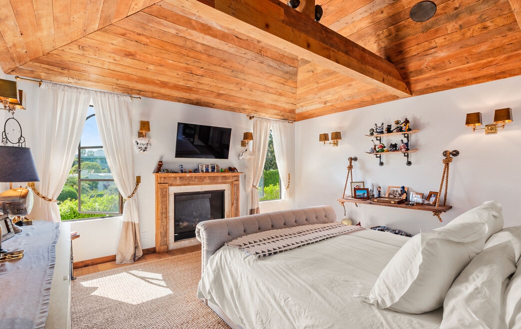 Primary bedroom with massive wood ceilings and a fabulous fireplace.