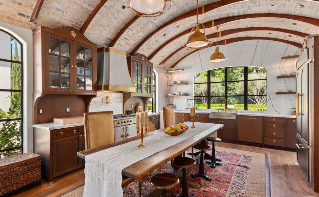 Fabulous kitchen with beamed barrel ceiling and huge center island table, custom built-in and walls of windows.