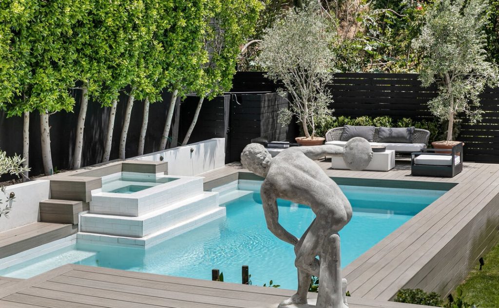 Lush lawn and sparkling pool embrace the rear yard.