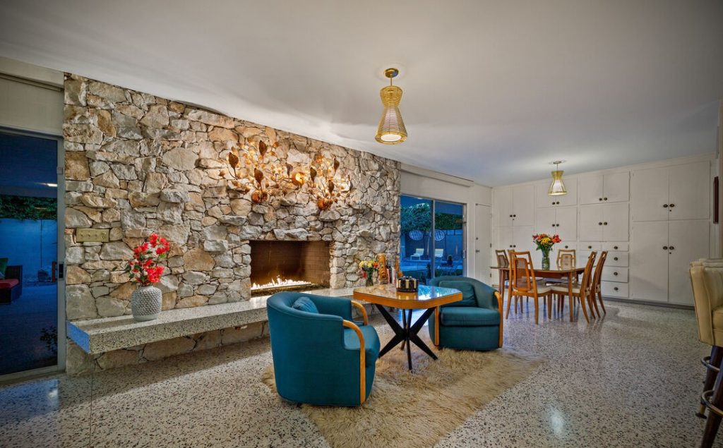 Palm Springs Quintessential living room with Massive Stone faced fireplace overlooks pool yard