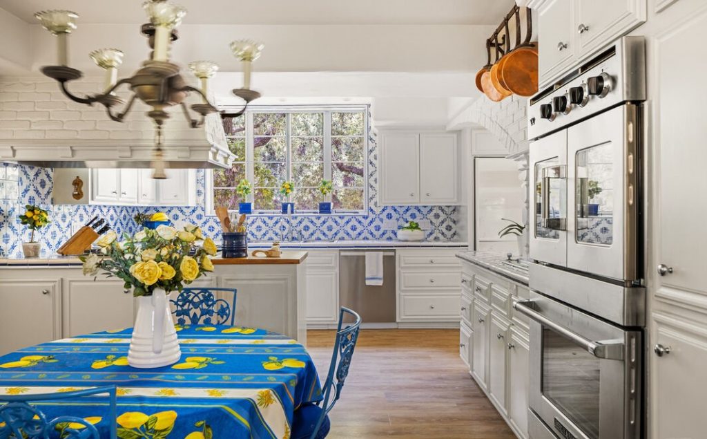 Magnificent Luxury Spanish huge open kitchen all white walls with brick arched accents and custom cornflower blue and white tile