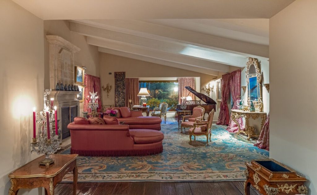 Truly a magnificent grand living room with painited beamed ceilings and dynamic fireplace