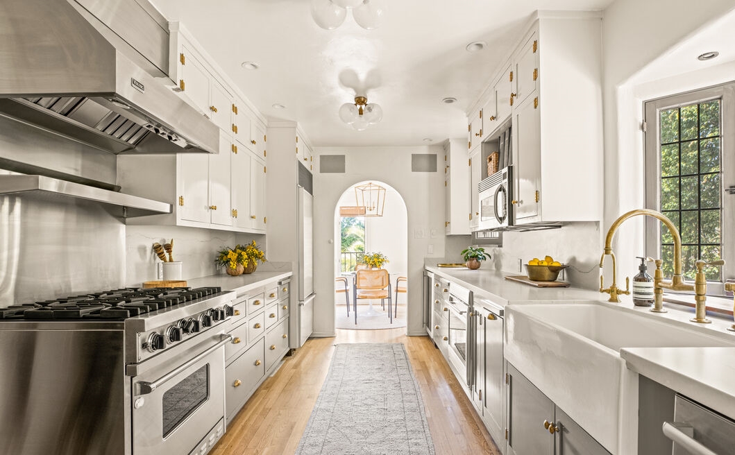 The chef-inspired kitchen boasts quartz marble countertops, stainless steel appliances, wine refrigerator, and custom cabinetry