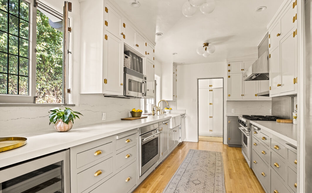The chef-inspired kitchen boasts quartz marble countertops, stainless steel appliances, wine refrigerator, and custom cabinetry 