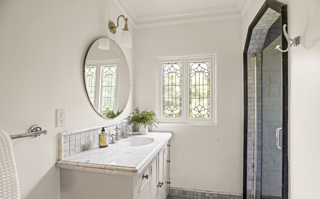 Striking white bathroom with black accent tiles to enhance.