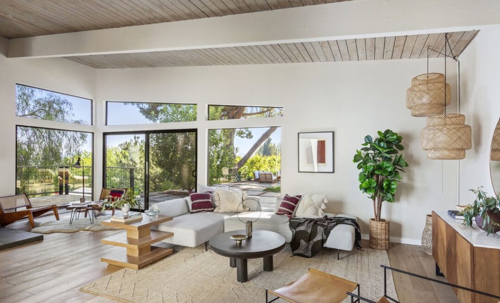 Wonderful living room with wood ceilings and walls of glass out to the gorunds