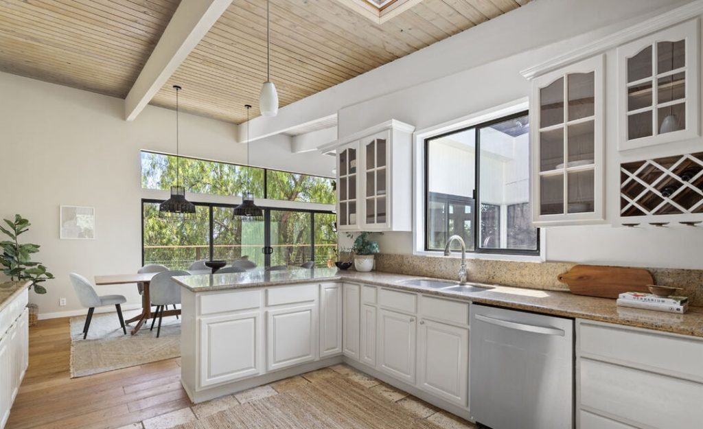 Remarkable open kitchen with gorgeous countertops, wood ceilings and skylights.