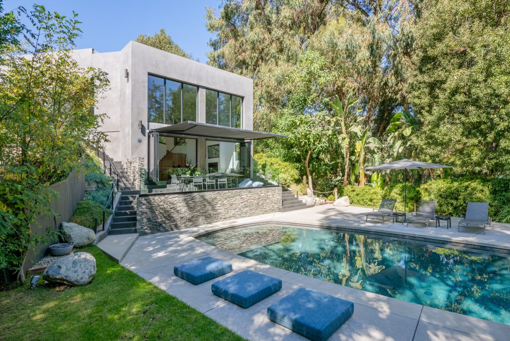 Hollywood Hills Exceptional stunning black bottom swimming pool is situated among a designed hardscape with room for rows of sun chairs.
