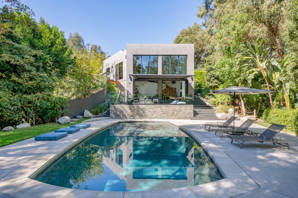 Hollywood Hills Exceptional A stunning black bottom swimming pool is situated among a designed hardscape with room for rows of sun chairs.