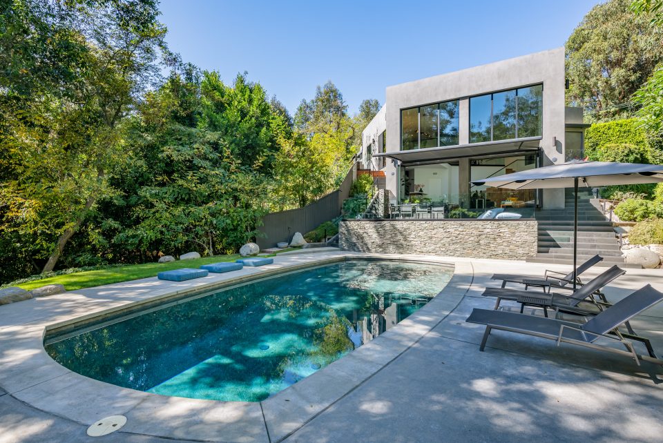 Hollywood Hills Exceptional stunning black bottom swimming pool is situated among a designed hardscape with room for rows of sun chairs.