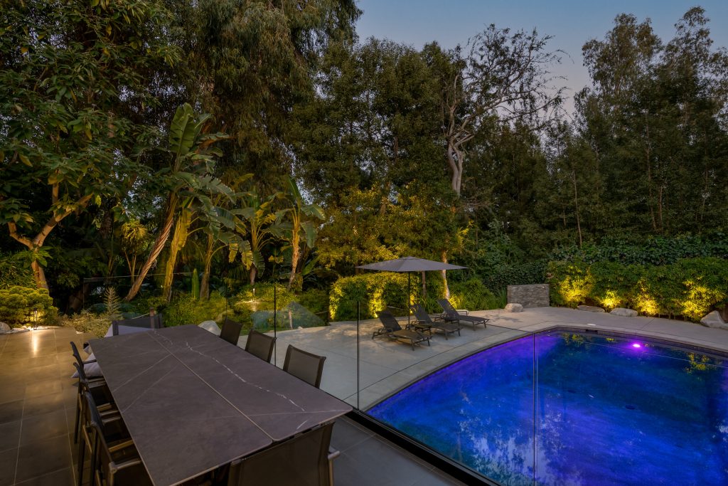 A stunning black bottom swimming pool is situated among a designed hardscape with room for rows of sun chairs.
