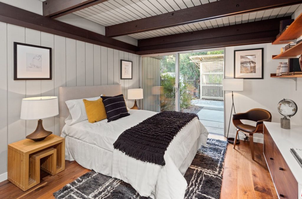 Walls of glass and stunning post and beam ceilings in Two separate bedroom wings allow simple functionality; three bedrooms on one side of the house and the primary suite on the other.