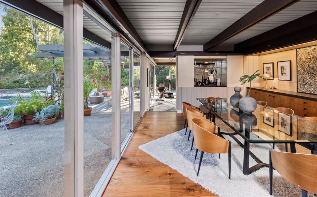 Floor to ceiling windows, sliding glass doors, post and beam design, flat roof and large overhangs define this one story masterpiece of indoor outdoor California living.