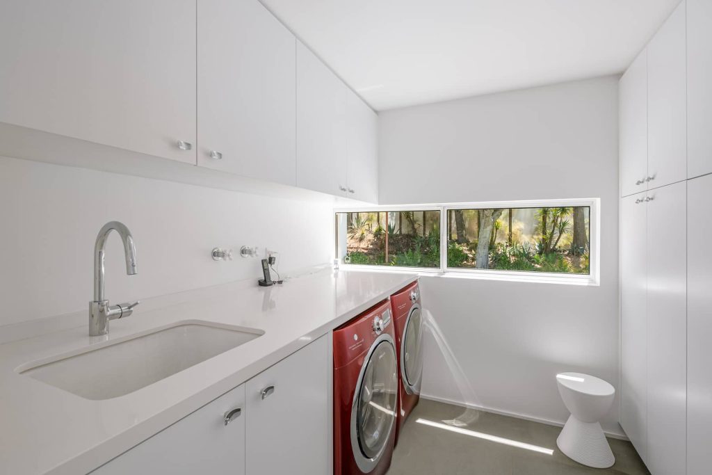 Clean lines and white walls in this architectural laundry room