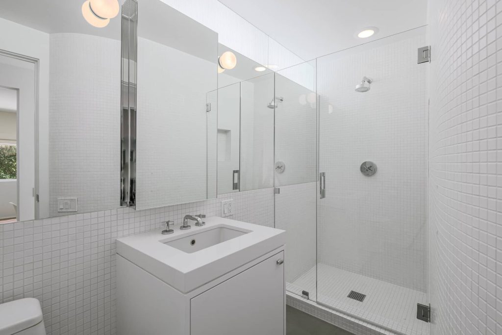 Clean lines, walls of glass, and white walls in this architectural bathroom. 