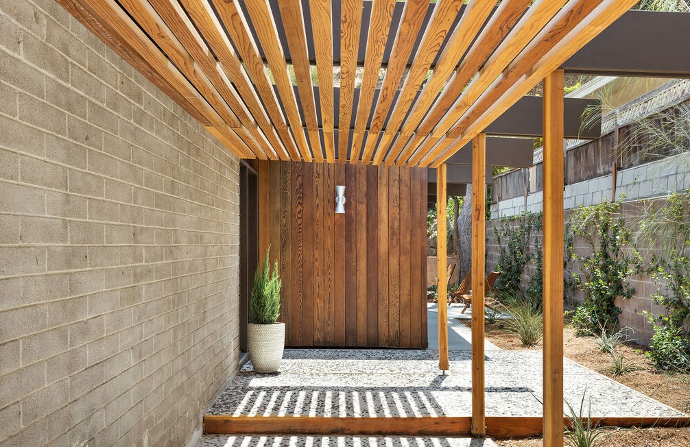 Horizontal massings of redwood siding and unpainted masonry block give privacy to a glass walled pavilion.