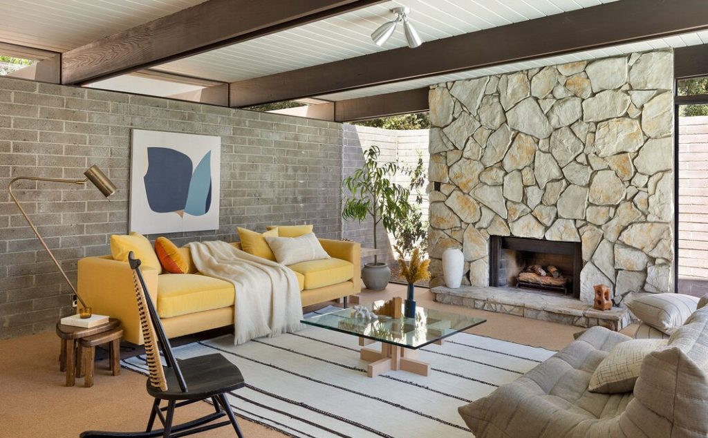 Massive stone fireplace, Horizontal massings of redwood siding and unpainted masonry block give privacy to a glass walled pavilion.