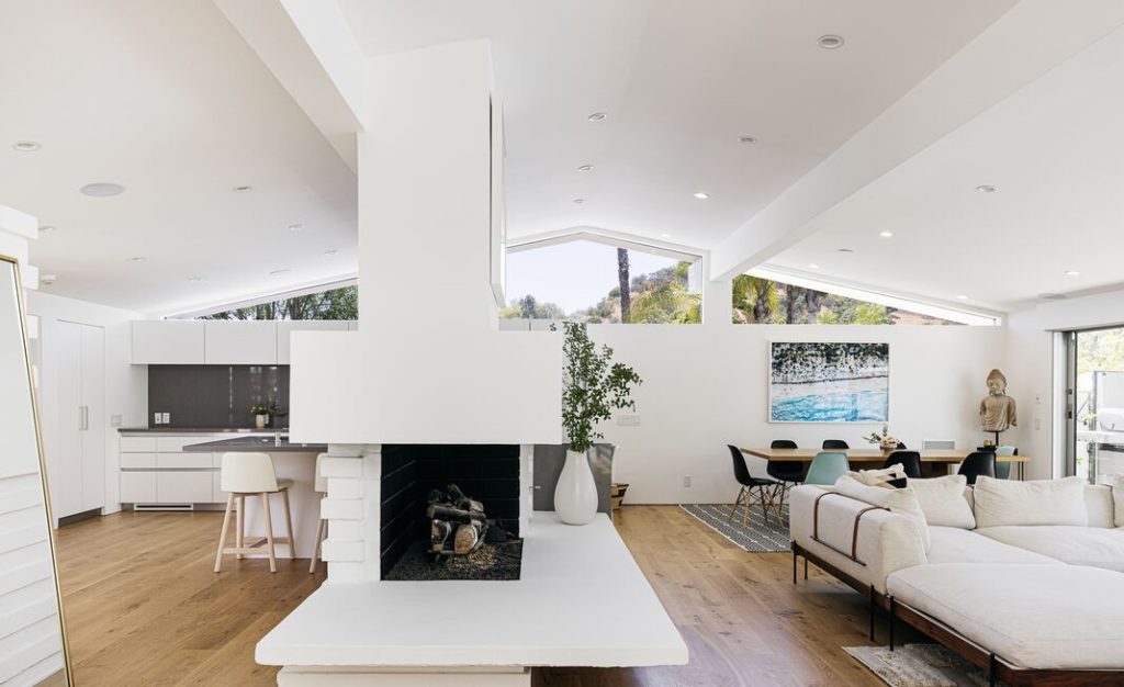 The main living space showcases Fickett's iconic post and beam design and central fireplace.