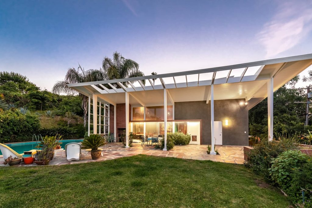 A classic sparkling kidney shaped swimming pool tops off the modern vibe.