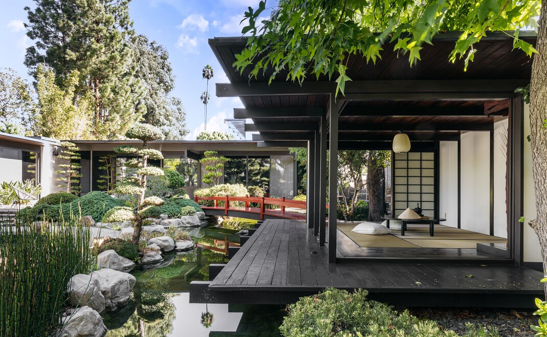 A serene garden courtyard sets a tranquil tone with cascading koi pond and contemplative landscaping