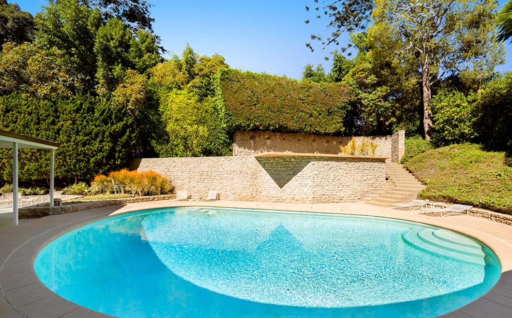 Beverly Hills Brilliant Mid Century Architectural presents an incredible round sparkling pool yard.
