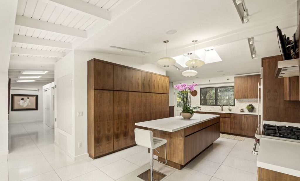 The beautiful kitchen features custom walnut cabinetry, Caesar stone island and counters, a Wolf Stove and Sub-Zero refrigerator.