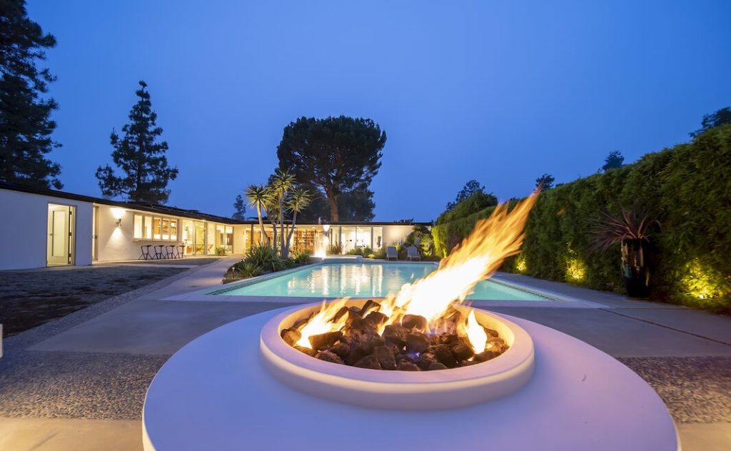 There is an oversized pool and beautiful fountain that dances all day and night across the pool from the fire-pit with built-in seating.