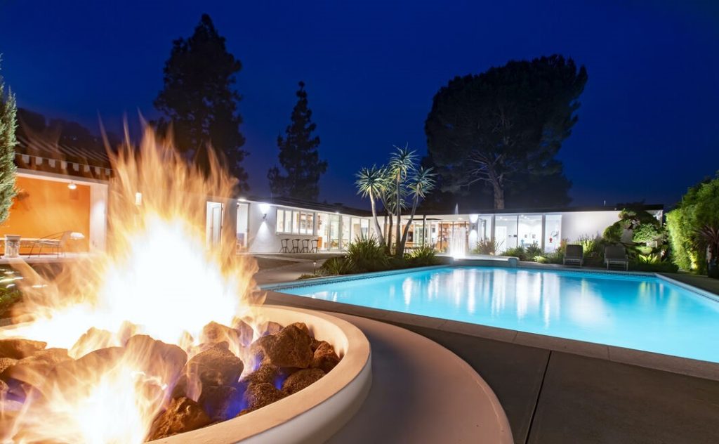 There is an oversized pool and beautiful fountain that dances all day and night across the pool from the fire-pit with built-in seating.