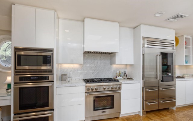 The kitchen has been remodeled with top-of-the-line stainless steel appliances and a glossy modern aesthetic that dovetails perfectly with the style of the home.
