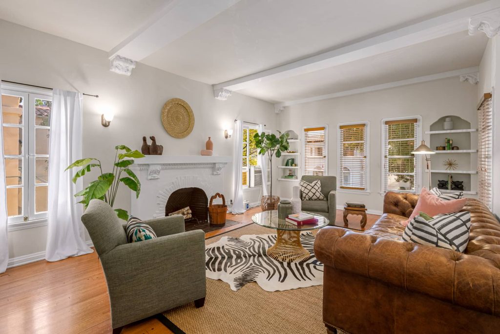 The high ceiling living rooms are lined with acanthus leaf corbeled beams, built-in shelves, and beautiful decorative fireplace.