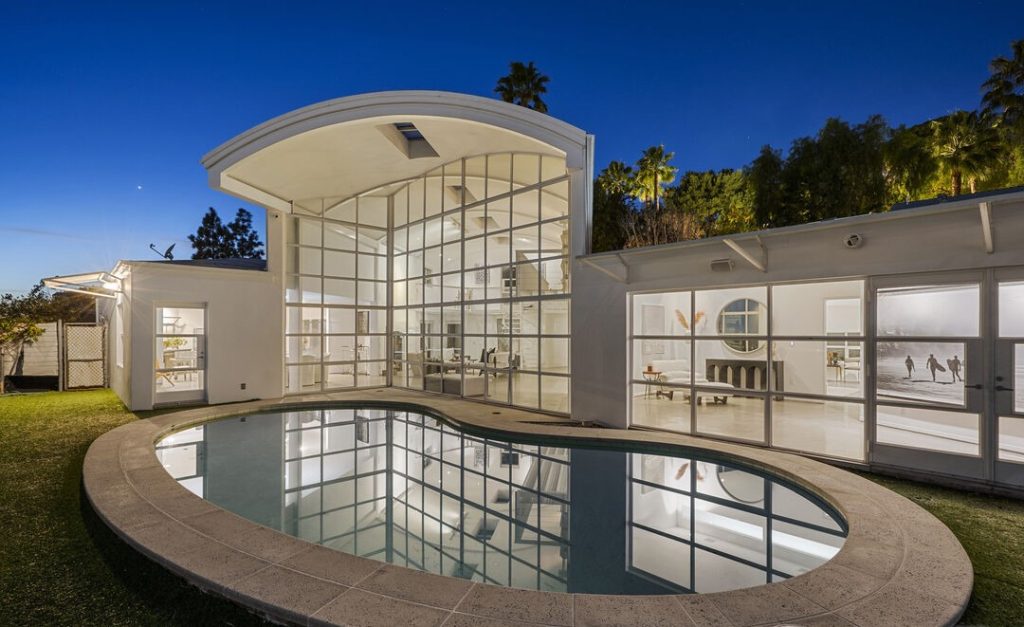 Hollywood Hills by celebrity architect Brian Murphy Doors lead out to the jacuzzi, large swimming pool, and sun lounging areas, on a grassy yard with BBQ.