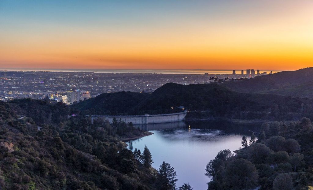 Set behind private gates, a winding drive leads to this extraordinary 3-acre ridgetop home with breathtaking 360-views over glimmering Lake Hollywood