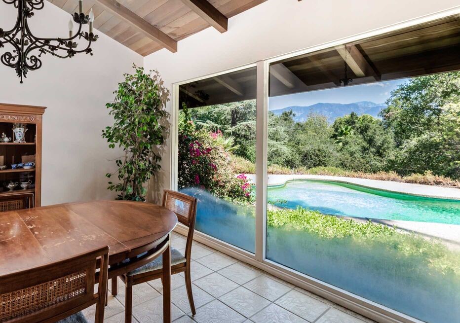 The spacious kitchen features a breakfast bar and blends seamlessly to a formal dining room with views of the pool and mountains.