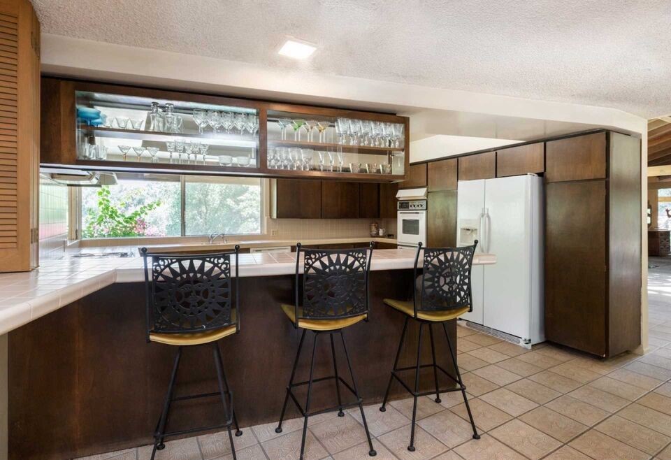 The spacious kitchen features a breakfast bar and blends seamlessly to a formal dining room with views of the pool and mountains.