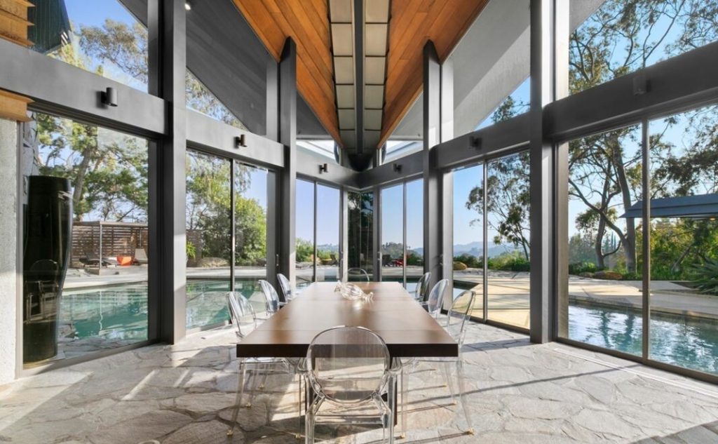 Soaring five-story living room harmoniously blends cathedral ceiling, walls of windows, tree-like columns and Bouquet Canyon stone