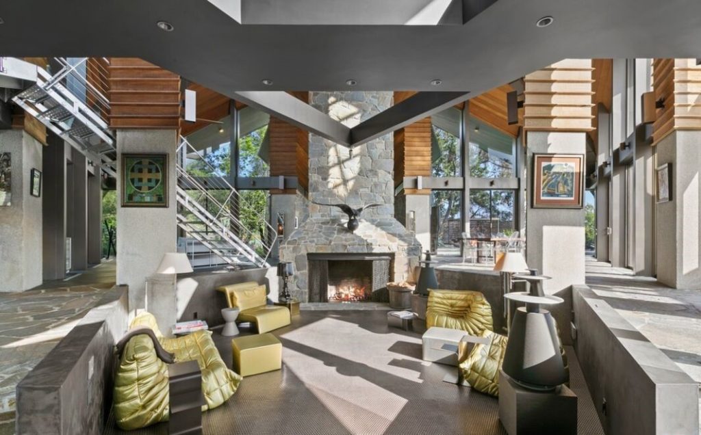 Soaring five-story living room harmoniously blends cathedral ceiling, walls of windows, tree-like columns and Bouquet Canyon stone